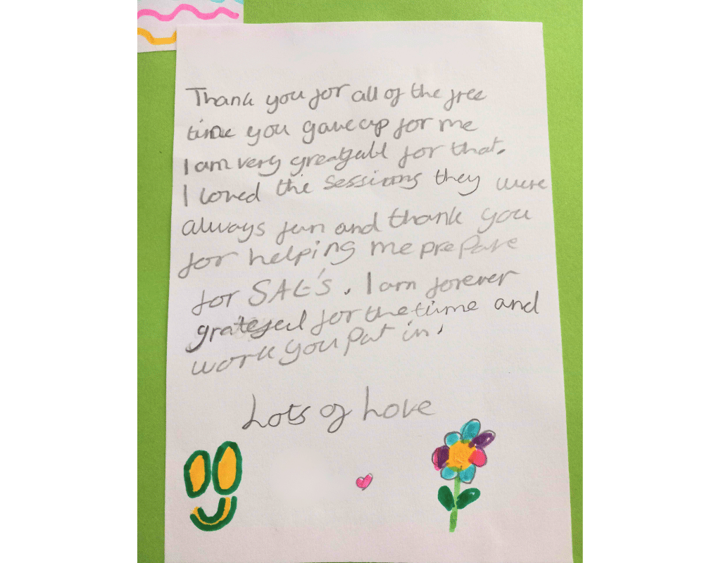 A multicoloured picture of a pupil's thank you note. The note is on a green background with a white foreground which also has a multicoloured smiley face and a flower at the bottom of the note, with a pink heart and a lots of love sign off.