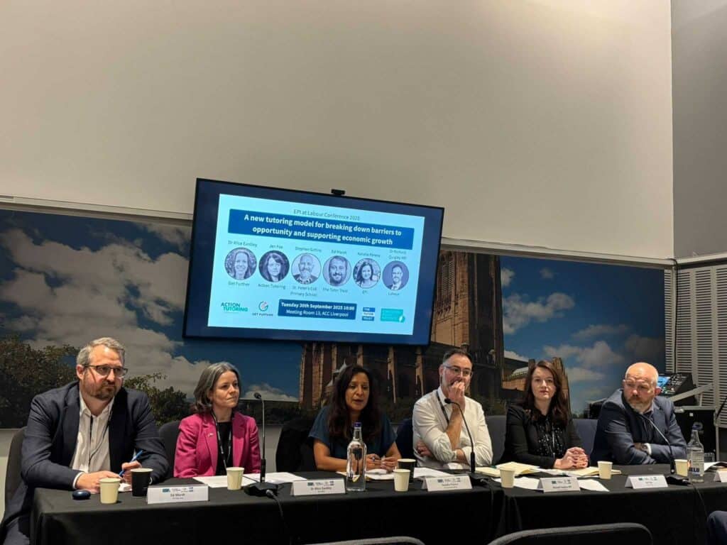 A picture of Action Tutoring CEO Jen Fox (second from right), sharing the stage at 
the Labour Party Conference with Tutor Trust CEO, Ed Marsh, 
Get Further's Dr Alice Eardley, the Education Policy Institute's Natalie Perera, 
Labour Party MP, Dr Richard Quigley, and St. Peter's CoE Primary School's Stephen Gittins 
(headteacher at one of our partner schools). The panellists are sitting at a table at the conference stage in Liverpool in front of a screen and backdrop with an image of Liverpool city centre. 