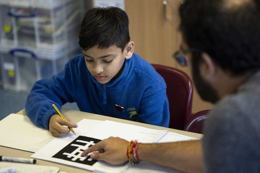 who we are - tutor with pupil